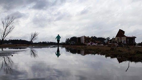 Marilyn Bullard makes her way to a home that was damaged by a tornado, Sunday, Jan. 22, 2017, in Adel, Ga.